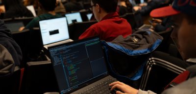 student working on laptop in class auditorium